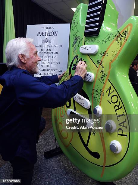 Kenny Rogers signs a giant Patron tequila guitar backstage at the CMA Awards to benefit the "Keep the Music Playing" music education on November 3,...