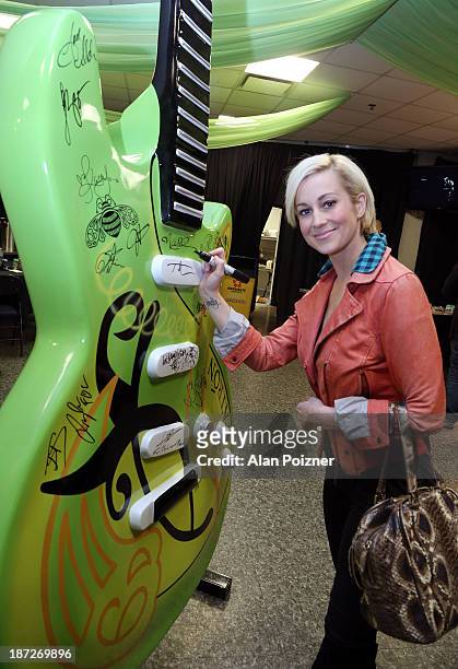 Kellie Pickler signs a giant Patron tequila guitar backstage at the CMA Awards to benefit the "Keep the Music Playing" music education on November 3,...