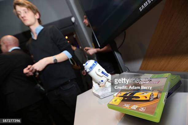XBox 360 games lie on a table next to a Star Wars R2-D2 figure, part of a Star Wars R2-D2 Xbox 360 video game console, at the opening of the...