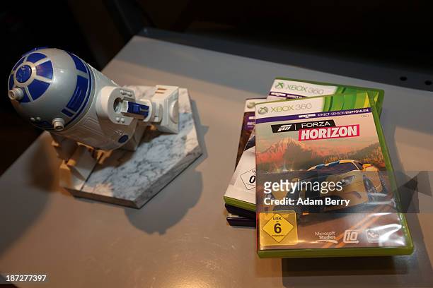 XBox 360 games lie on a table next to a Star Wars R2-D2 figure, part of a Star Wars R2-D2 Xbox 360 video game console, at the opening of the...