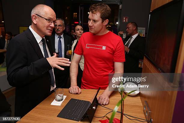 Guest talks to a Microsoft employee at the opening of the Microsoft Center Berlin on November 7, 2013 in Berlin, Germany. The Microsoft Center...