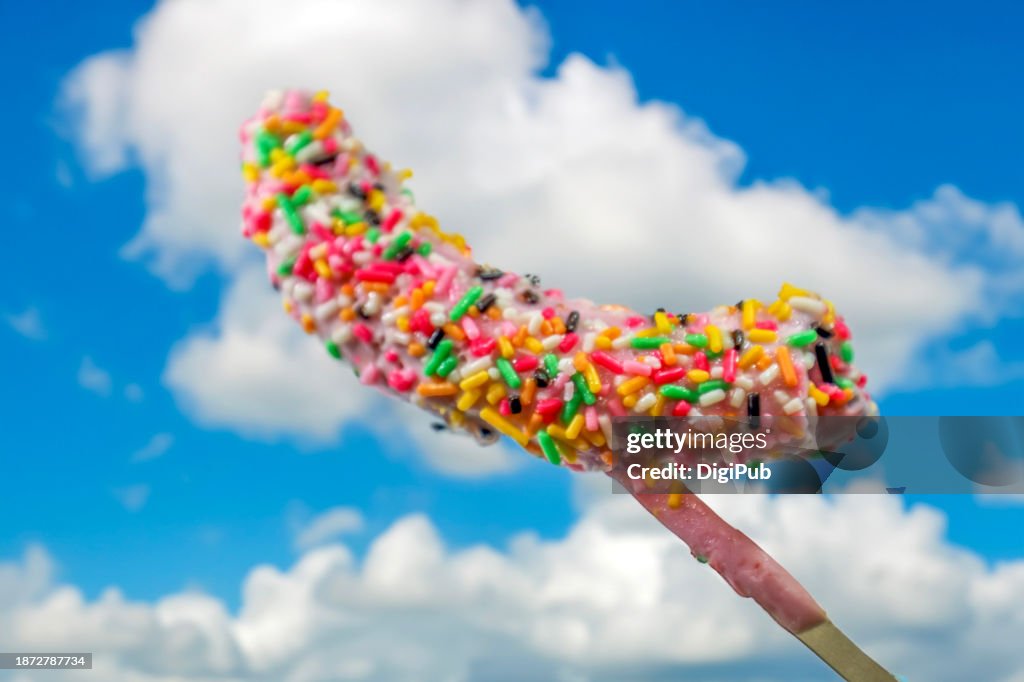 Pink Chocolate Covered Banana with Sprinkles Pop Against Blue Sky