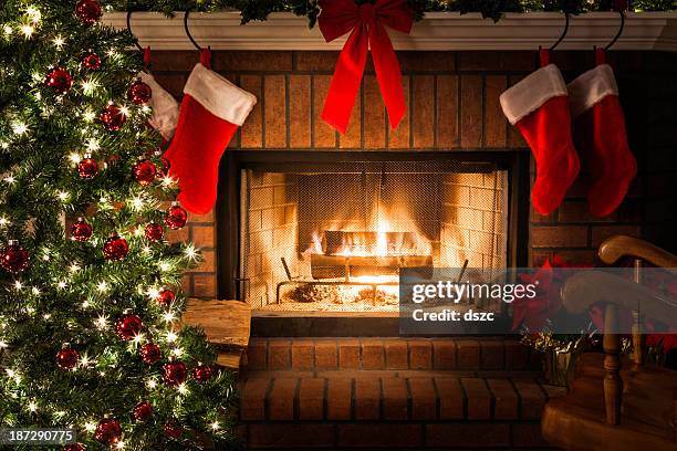 decorated christmas tree, blazing fire in fireplace, stockings, rocking chair - fireplace 個照片及圖片檔