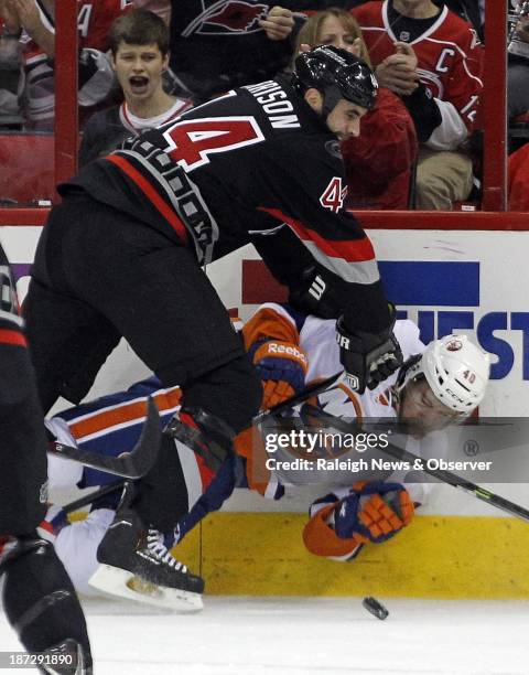 Jay Harrison of the Carolina Hurricanes decks Michael Grabner of the New York Islanders as they go for the puck during the second period at the PNC...