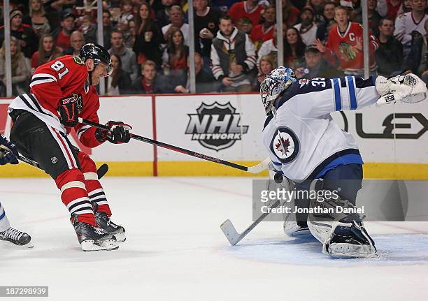 Al Montoya of the Winnipeg Jets stops a shot by Marian Hossa of the Chicago Blackhawks at the United Center on November 6, 2013 in Chicago, Illinois....