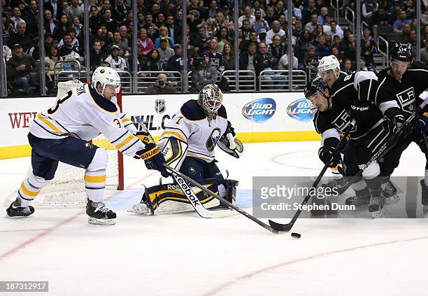 Drew Doughty of the Los Angeles Kings and Mark Pysyk of the Buffalo Sabres fight for the puck in front of Sabres goali Jhonas Enroth at Staples...