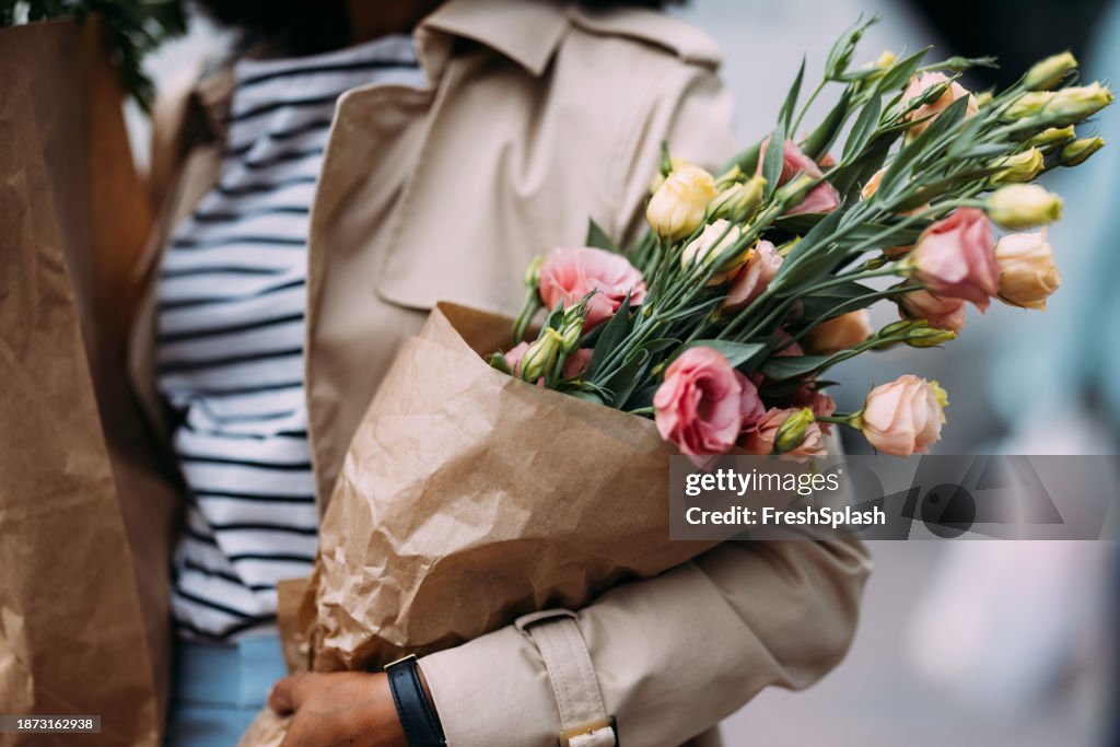 食料品と花を持つ見分けがつかない買い物客