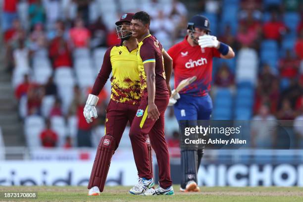 Gudakesh Motie and Nicholas Pooran of West Indies celebrate the wicket of Liam Livingstone of England during the 5th T20 International between the...