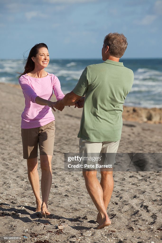 Middle aged couple walking on beach