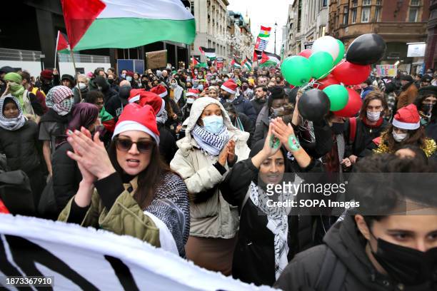 Protesters march down Oxford Street wearing Father Christmas hats during the demonstration. Sisters Uncut supporters gathered and marched in the West...