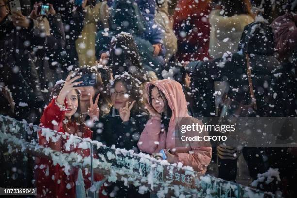 People celebrate Christmas Eve amid artificial snowflakes at a shopping mall in Liangjiang New District, Chongqing, China, December 24, 2023.