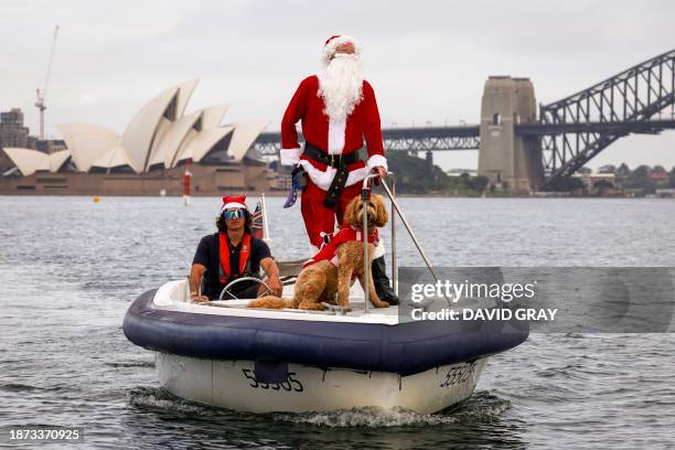 Man dressed as Santa Claus rides a boat with his dog in front of the Sydney Opera House, as part of Christmas Day celebrations for the annual Sydney...