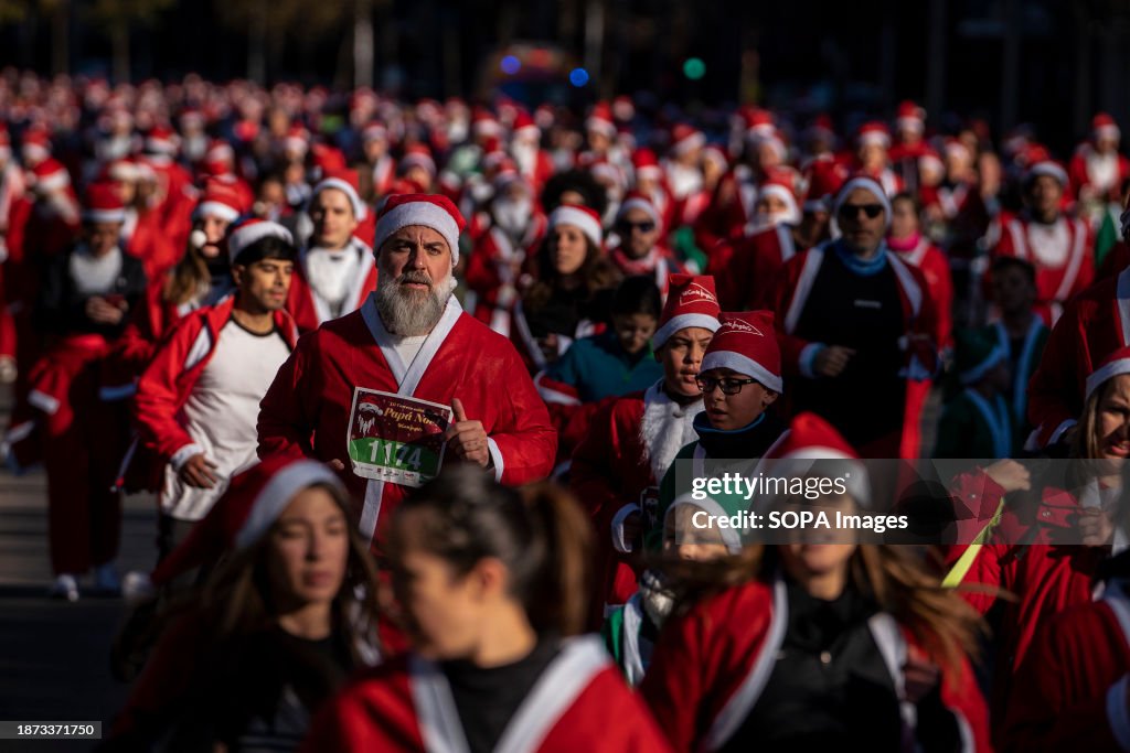 Thousands of people dressed as Santa Claus run during the...