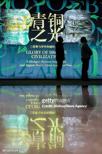 People visit an exhibition titled "Glory of Bronze Civilization" in the Museum of Shanghai University in Shanghai, east China, Dec. 22, 2023. The...