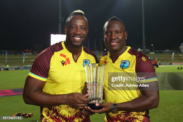 Rovman Powell, captain of West Indies and teammate Andre Russell pose for a photo with the winner's trophy after the 5th T20 International between...