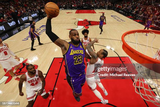 LeBron James of the Los Angeles Lakers dunks over DeMar DeRozan of the Chicago Bulls during the first half at the United Center on December 20, 2023...