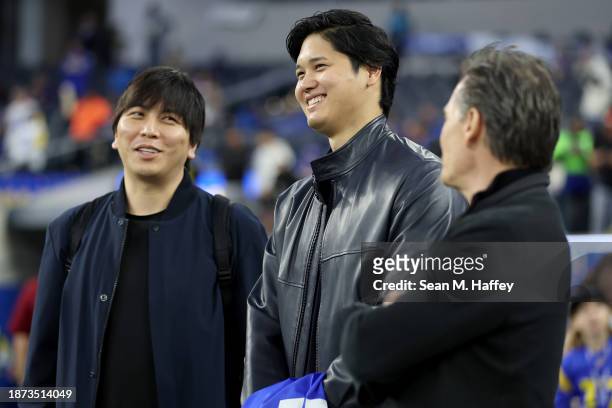 Shohei Ohtani of the Los Angeles Dodgers talks with his interpreter Ippei Mizuhara and agent Nez Balelo prior to the game between the New Orleans...