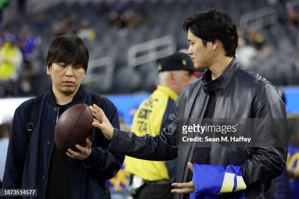 Shohei Ohtani of the Los Angeles Dodgers talks with his interpreter Ippei Mizuhara prior to the game between the New Orleans Saints and the Los...