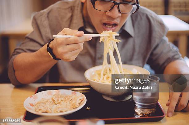 man eating udon - udon noodle stock pictures, royalty-free photos & images