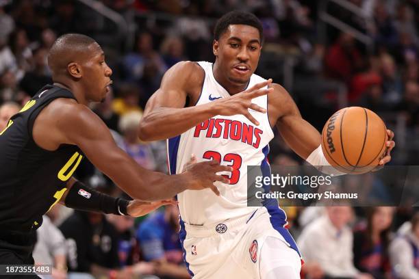 Jaden Ivey of the Detroit Pistons tries to drive around Kris Dunn of the Utah Jazz during the first half at Little Caesars Arena on December 21, 2023...