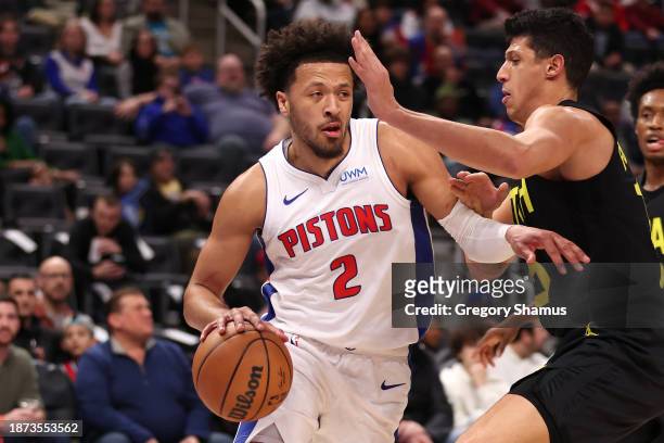 Cade Cunningham of the Detroit Pistons drives around Simone Fontecchio of the Utah Jazz during the first half at Little Caesars Arena on December 21,...