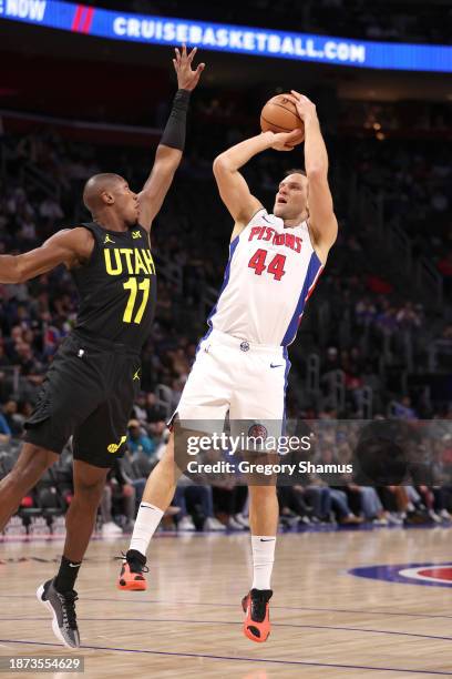 Bojan Bogdanovic of the Detroit Pistons takes a first half shot over Kris Dunn of the Utah Jazz at Little Caesars Arena on December 21, 2023 in...