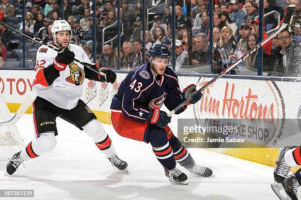 Sean Collins of the Columbus Blue Jackets and Eric Gryba of the Ottawa Senators chase after a loose puck on November 5, 2013 at Nationwide Arena in...