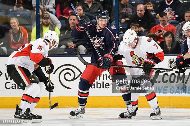 Artem Anisimov of the Columbus Blue Jackets and Kyle Turris of the Ottawa Senators battle for control of the puck on a face off on November 5, 2013...