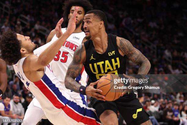 John Collins of the Utah Jazz drives against Cade Cunningham of the Detroit Pistons during the second half at Little Caesars Arena on December 21,...