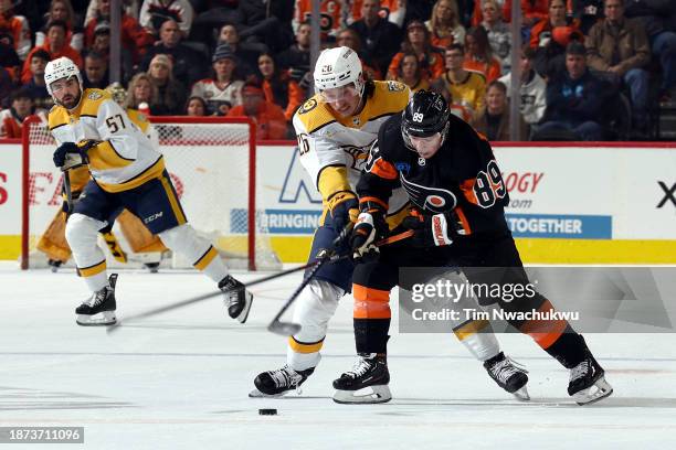 Philip Tomasino of the Nashville Predators and Cam Atkinson of the Philadelphia Flyers challenge for the puck during the third period at the Wells...