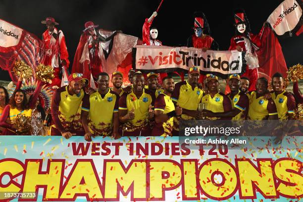 West Indies players celebrate with the winner's trophy after the 5th T20 International between the West Indies and England at the Brian Lara Cricket...
