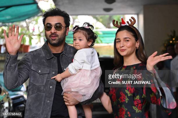 Bollywood actors Ranbir Kapoor and his wife Alia Bhatt pose with their daughter Raha upon their arrival for a Christmas brunch in Mumbai on December...