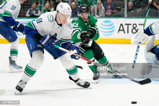 Wyatt Johnston of the Dallas Stars and Nikita Zadorov of the Vancouver Canucks compete for the puck during the third period at American Airlines...