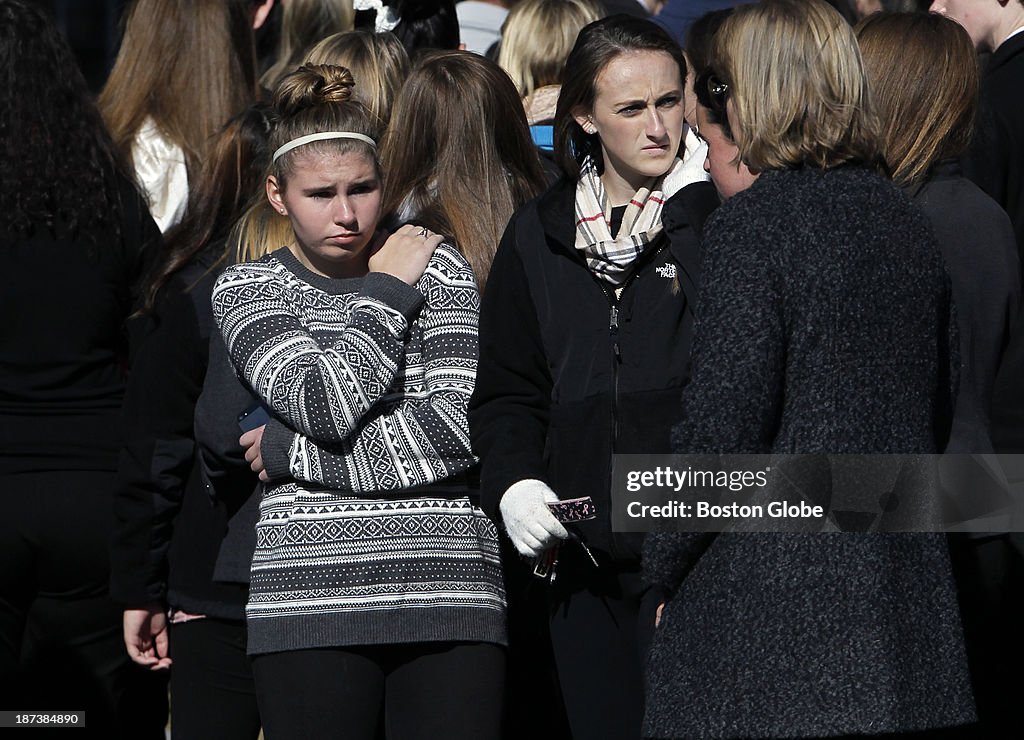 Mourners watch as the funeral procession passes by. The funeral for