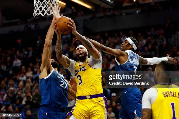 Anthony Davis of the Los Angeles Lakers is fouled by Rudy Gobert of the Minnesota Timberwolves while Jaden McDaniels of the Minnesota Timberwolves...