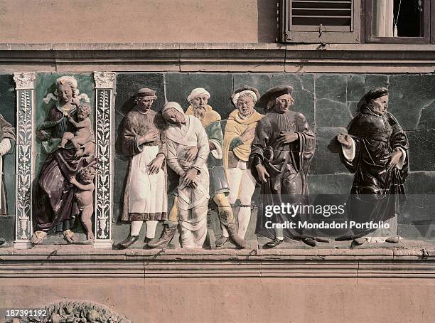 Italy, Tuscany, Pistoia, Ospedale del Ceppo, Detail, Decorative frieze depicting some well-to-do men who make a good deed by burying a bandaged...