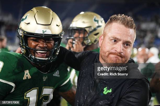 Israel Carter of the South Florida Bulls and head coach Alex Golesh celebrate after defeating the Syracuse Orange in the RoofClaim.com Boca Raton...