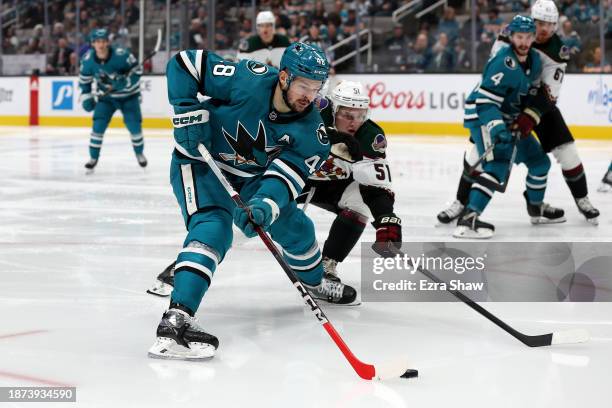 Tomas Hertl of the San Jose Sharks keeps the puck from Troy Stecher of the Arizona Coyotes in the second period at SAP Center on December 21, 2023 in...