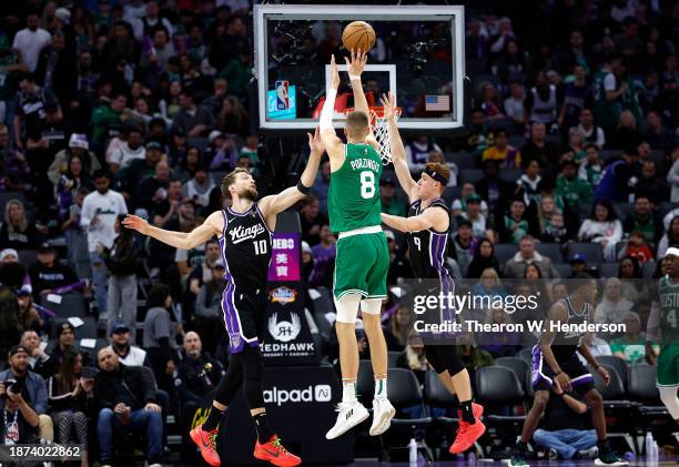 Kristaps Porzingis of the Boston Celtics shoots over Domantas Sabonis and Kevin Huerter of the Sacramento Kings during the second half of an NBA...