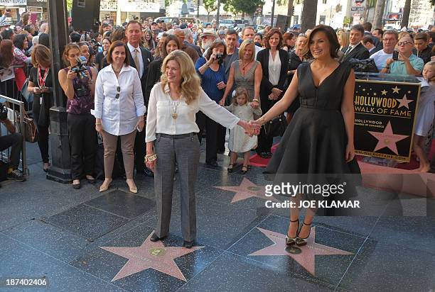 Actress Mariska Hargitay stands on her star while her sister Tina Hargitay stands on the star of their mother Jayne Mansfield on November 8, 2013...