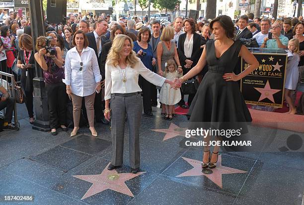 Actress Mariska Hargitay stands on her star while her sister Tina Hargitay stands on the star of their mother Jayne Mansfield on November 8, 2013...