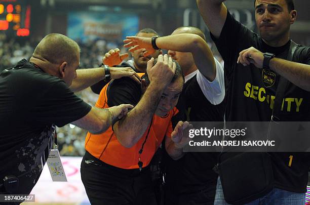 Security officers protect a referee after the Euroleague group A basketball match Fenerbahce Istanbul against Partizan Belgrade in Belgrade on...