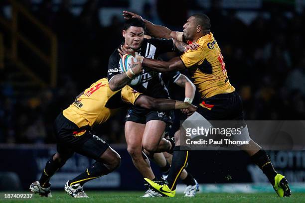 Issac Luke of New Zealand is tackled by Jason Tali and Jessie Joe Nandye of Papua New Guinea during the Rugby League World Cup Group B match at...
