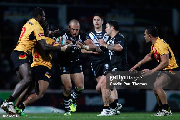 Sam Moa of New Zealand is tackled by Sebastien Pandia and Joe Bruno of Papua New Guinea during the Rugby League World Cup Group B match at Headingley...