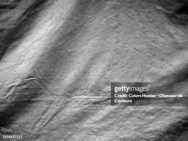 black and white close-up of a crumpled plastic tarpaulin in london, england, united kingdom. - ruffled sheets stock pictures, royalty-free photos & images
