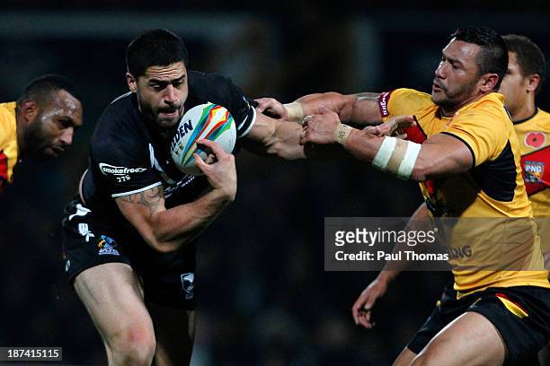 Jesse Bromwich of New Zealand is tackled by Jason Chan of Papua New Guinea during the Rugby League World Cup Group B match at Headingley Stadium on...