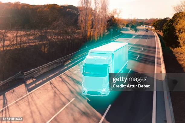 blue trailer truck glowing on a highway with the autonomous driving smart technology. - autopilot stock-fotos und bilder