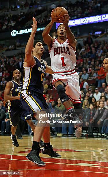 Derrick Rose of the Chicago Bulls goes up for a shot over Enes Kanter of the Utah Jazz at the United Center on November 8, 2013 in Chicago, Illinois....