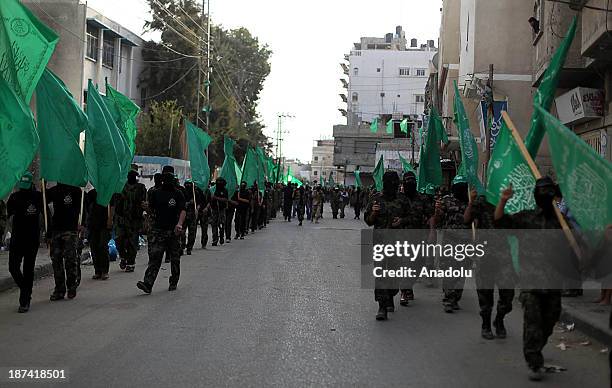 Members of the Ezzeddin al-Qassam, the military wing of Hamas, march during an anti-Israel protest on the first anniversary of Israel's Operation...