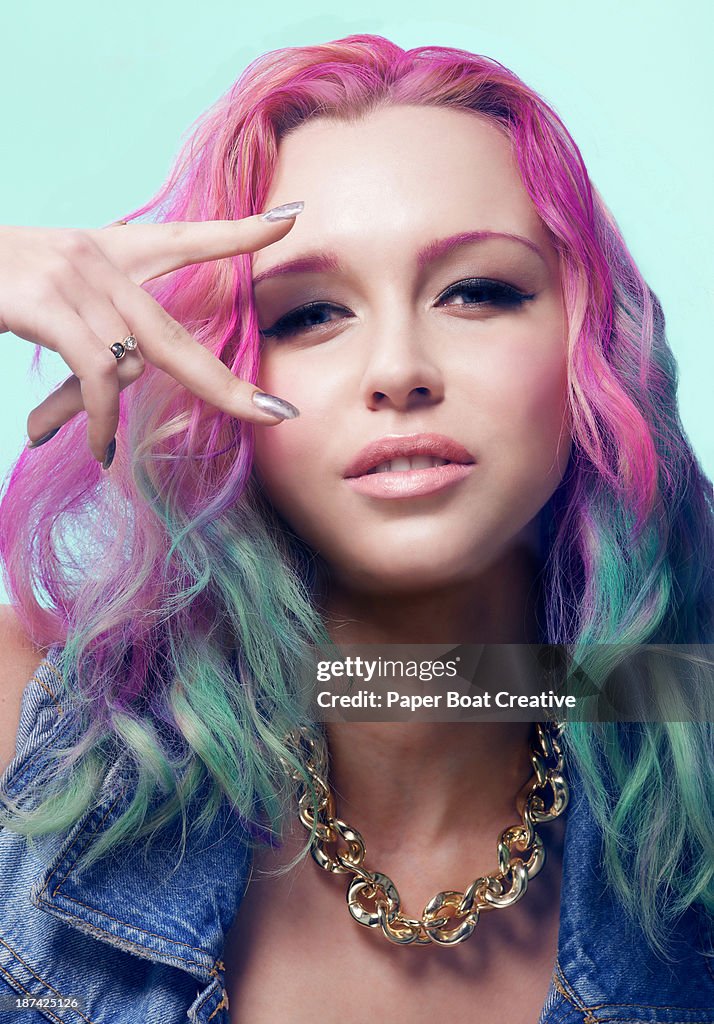 Lady with colorful hair making the peace sign